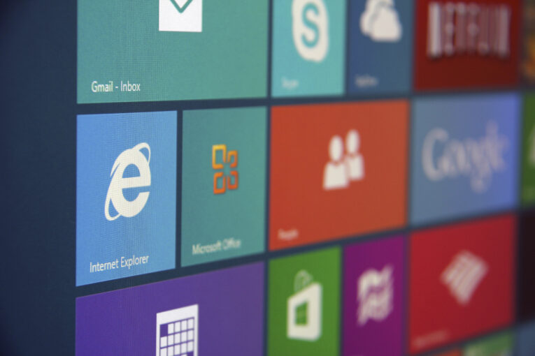 Close-up of a computer screen showing various application icons, including Microsoft Office, Skype, Google, and a reminder that support for older versions of Internet Explorer ends soon.