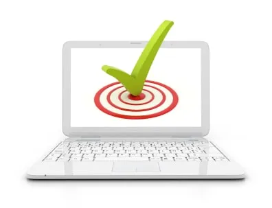 A white laptop displaying an image of a green checkmark over a red target on its screen.