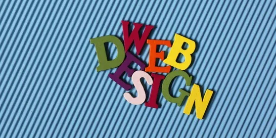 Colorful, three-dimensional letters spelling "WEB DESIGN" are arranged on a blue, diagonally striped background.