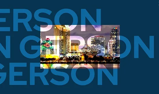 Skyline of a city lit up at night, with tall buildings and colorful lights, overlaid on a blue background with large blue text partially visible.