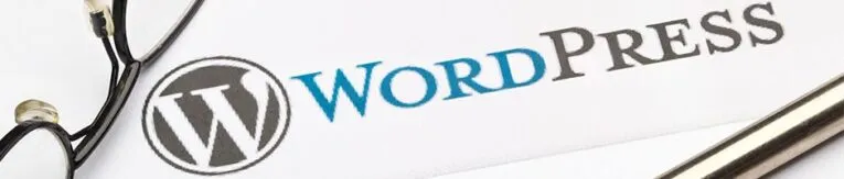 Close-up of a WordPress logo on a white surface with a pen and eyeglasses nearby, reminiscent of the cover design for "Getting Started with WordPress: A Quick Guide for Beginners.