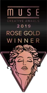 Image of a "Muse Creative Awards 2019 Rose Gold Winner" graphic featuring an illustrated face of a woman with flowing hair inside a triangular frame.