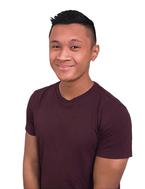 Young man in a maroon t-shirt smiling, standing against a white background.