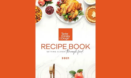Cover of a recipe book titled "Tarter Krinsky & Drogin Recipe Book 2021", featuring a roasted chicken, pie, and various dishes against a white background with an orange border.