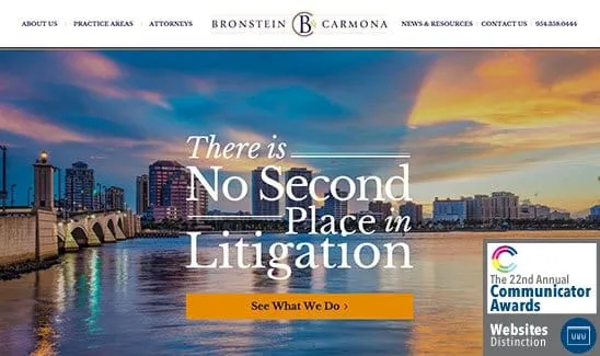 Website of Bronstein & Carmona law firm, featuring the message “There is No Second Place in Litigation,” with a cityscape background and an award badge for the 22nd Annual Communicator Awards.