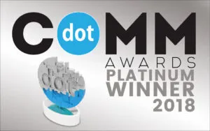 Image of a DotCOMM Awards certificate displaying "DotCOMM Awards Platinum Winner 2018" alongside a logo featuring a circular blue dot with the word "dot" and a stylized trophy image.