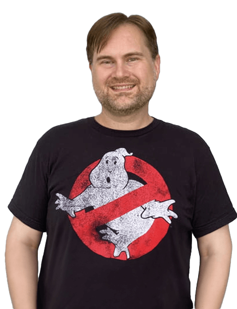 A man wearing a black T-shirt with the Ghostbusters logo stands smiling.