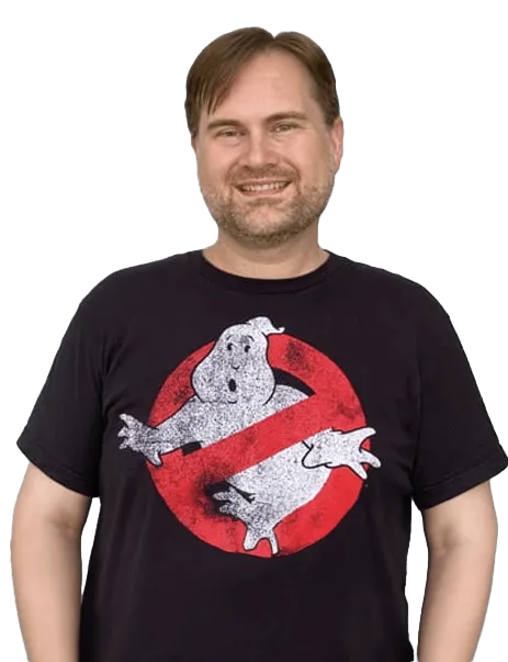 A man wearing a black T-shirt with the Ghostbusters logo stands smiling.