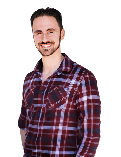 A man with a beard and mustache smiles while wearing a red plaid shirt.
