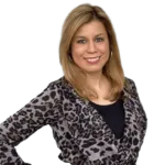 A woman with shoulder-length blonde hair is smiling. She is wearing a leopard-print top over a black shirt.