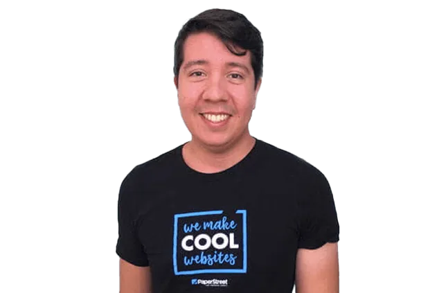 A man smiles while wearing a black t-shirt that reads "we make COOL websites" and "PaperStreet" at the bottom.