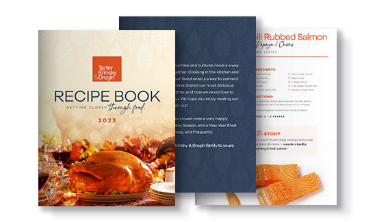 A 2023 recipe book from Tarter, Krinsky & Drogin featuring a cover with a roasted turkey and two interior pages showing a blue introduction page and a chili-rubbed salmon recipe page.