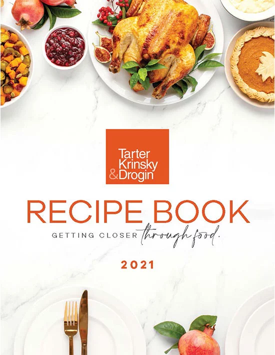 Cover of the "Tarter Krinsky & Drogin Recipe Book 2021" featuring a roasted turkey, cranberry sauce, squash, figs, and a pie, with the text, "Getting Closer Through Food".