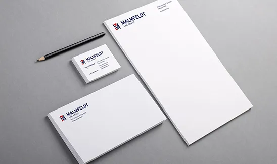 A set of corporate stationery on a gray surface, including a business card, a pencil, an envelope, and letterhead paper, all branded with "Maañfeldt Legal Services" logo and name.