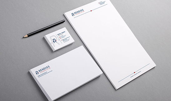 A flat lay image of branded office stationery, including a letterhead, business cards, an envelope, and a pencil, on a gray background. The items feature the "ReindigS" logo and contact details.