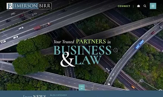 Aerial view of highway interchange with the text "Your Trusted Partners in Business & Law" and "Jimerson Birr" in the corners. Website navigation options are visible at the top of the image.