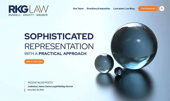 Homepage of RKG Law firm featuring floating translucent spheres, with text promoting sophisticated representation and a practical approach. Navigation links and a section for recent blog posts are also visible.