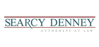 Logo of Searcy Denney Attorneys at Law, featuring the firm's name in blue uppercase text with red horizontal lines above and below.