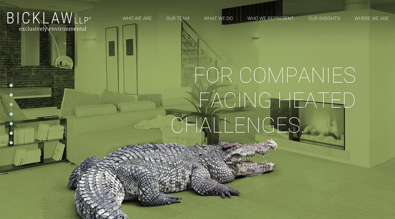A large crocodile lies on the floor in front of a modern living room set. The background features a staircase and text overlay reads, "For companies facing heated challenges.