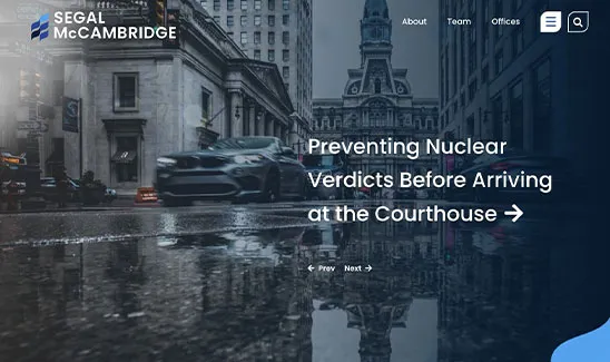 City street view with cars driving past buildings on a rainy day. Text reads "Preventing Nuclear Verdicts Before Arriving at the Courthouse." Segal McCambridge logo and navigation options are visible.