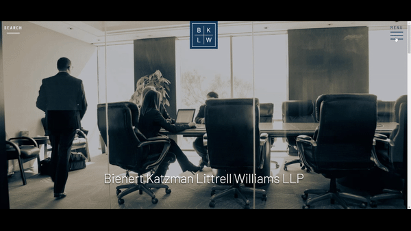 Two people sit at a conference table with laptops in a glass-walled meeting room while one person stands nearby. Text reads "Bienert Katzman Littrell Williams LLP.