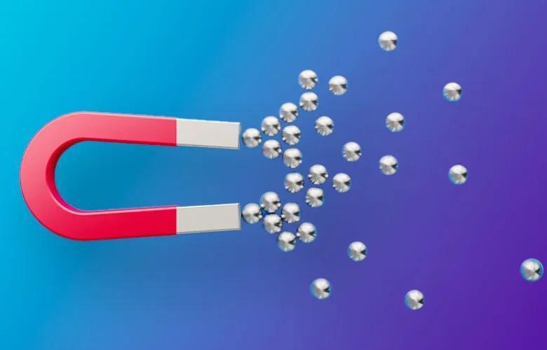 A red horseshoe magnet attracting multiple small metallic spheres on a blue gradient background.