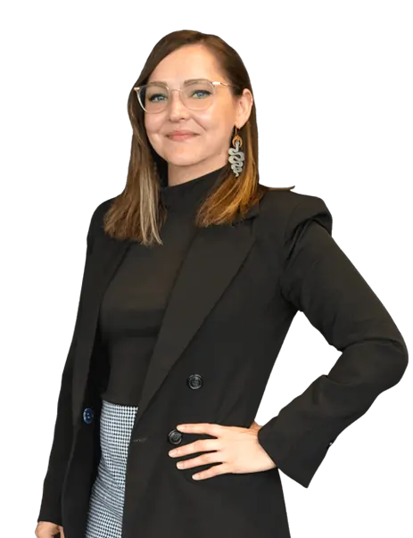 Marissa Blandford, wearing glasses and a black blazer, stands smiling confidently at the camera.