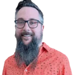 Man with glasses and a long beard wearing an orange patterned shirt, smiling at the camera.