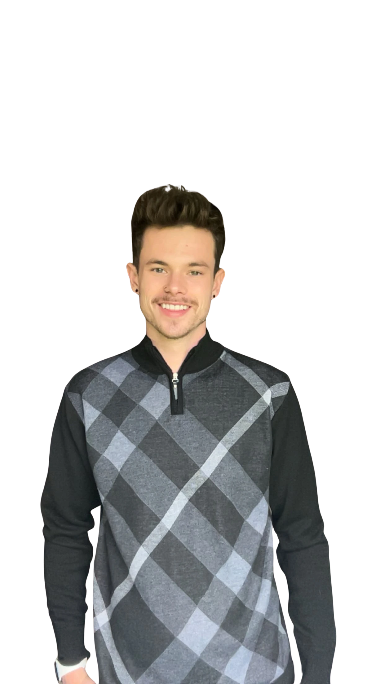 Man in a black and gray argyle sweater stands and smiles against a plain white background.