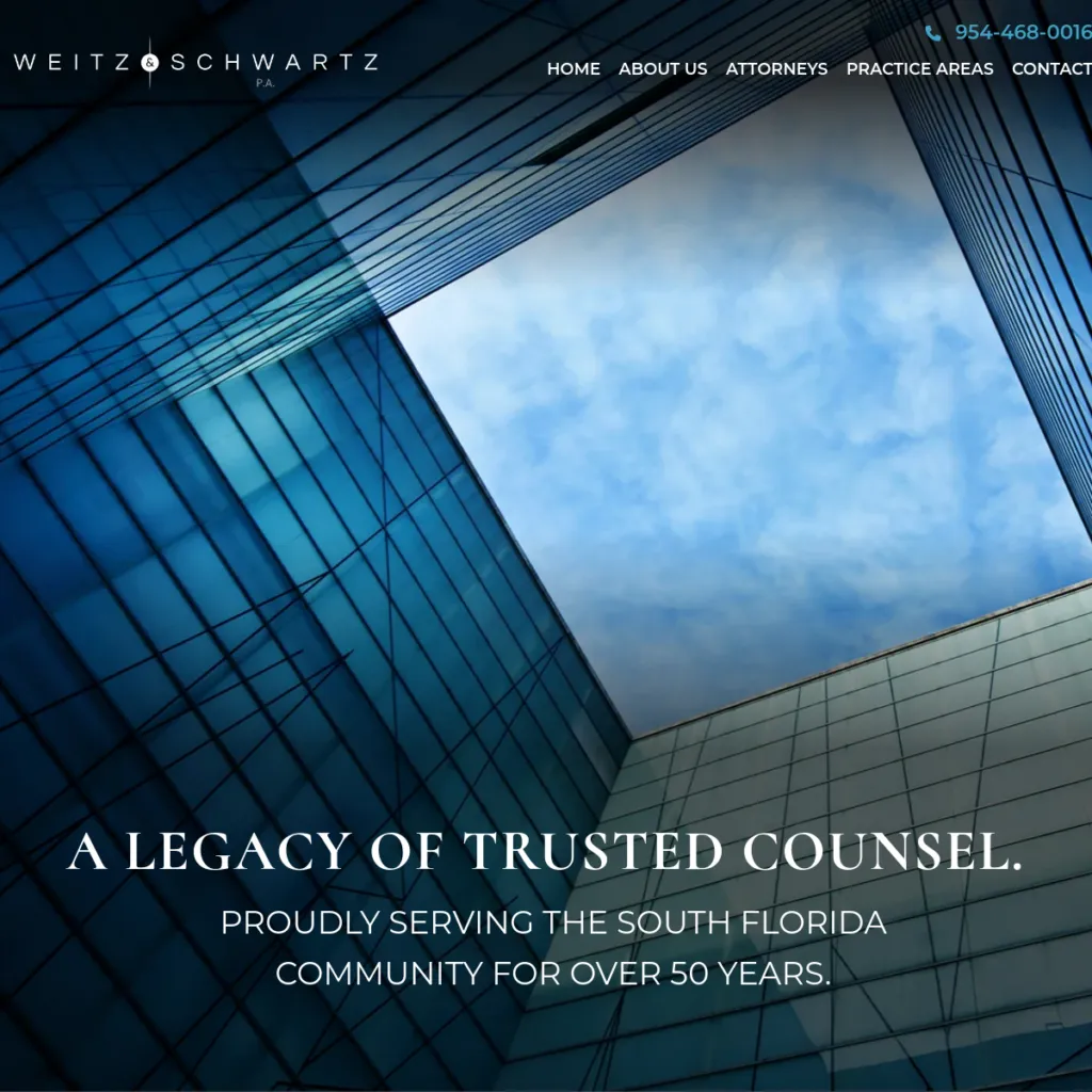 View looking up at glass skyscrapers with a blue sky, featuring a law firm’s website text overlay.
